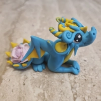 Baby Blue Dragon Figure with a paper flower